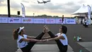 Sekitar 500 peserta yoga dan influencer yang siap dengan kamera mulai berdatangan pada pukul 5:00 pagi, berjalan dalam kegelapan menuju matras mereka di landasan pacu. (MANAN VATSYAYANA / AFP)