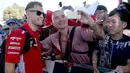 Pembalap tim Ferrari, Sebastian Vettel berswafoto dengan fans sesaat sebelum latihan bebas Formula 1 (F1) GP Australia di Melbourne, Jumat (23/3). Balapan F1 GP Australia 2018 sendiri akan bergulir pada Minggu, 25 Maret besok. (AP/Rick Rycroft)