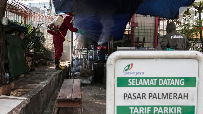 Petugas menyemprotkan Cairan Disinfektan di Pasar Palmerah, Jakarta, Kamis (25/6/2020). Pada hari ini pasar pelmerah resmi ditutup selama 3 hari kedepan dikarenakan 9 pedagang dinyatakan positif Covid-19. (Liputan6.com/Johan Tallo)