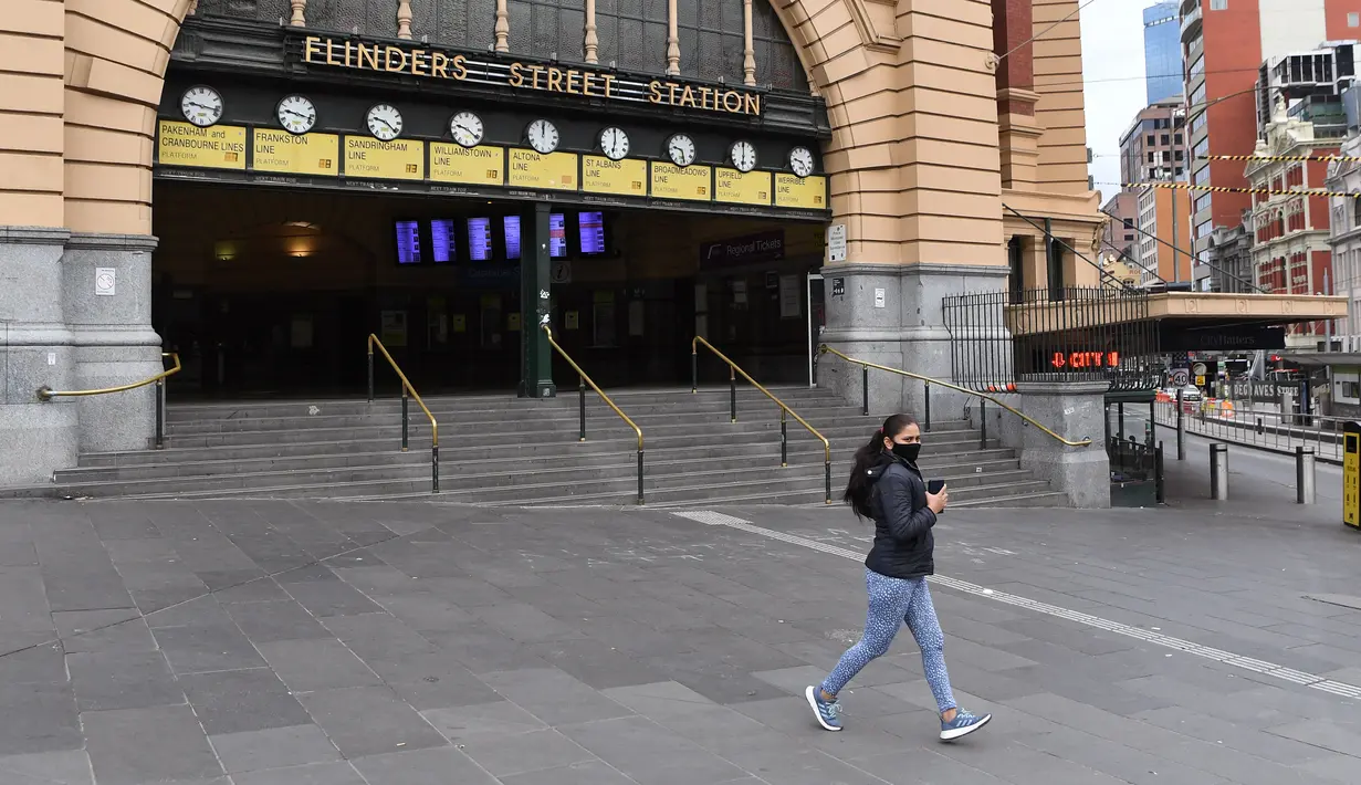 Warga berlari melewati Stasiun Flinder Street yang hampir sepi selama jam sibuk pagi hari ketika pemberlakukan lockdown di Melbourne, Jumat (28/5/2021). Melbourne kembali menerapkan lockdown untuk keempat kalinya setelah wabah COVID-19 menyebar cepat di wilayah tersebut. (William WEST/AFP)