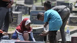 Kelompok anak-anak membersihkan salah satu makam di TPU Penggilingan, Pulogadung, Jakarta, Kamis (10/5). Tradisi ziarah jelang Ramadan menjadi berkah bagi anak-anak pembersih makam atau biasa dikenal 'Ngoret'. (Merdeka.com/Iqbal S. Nugroho)