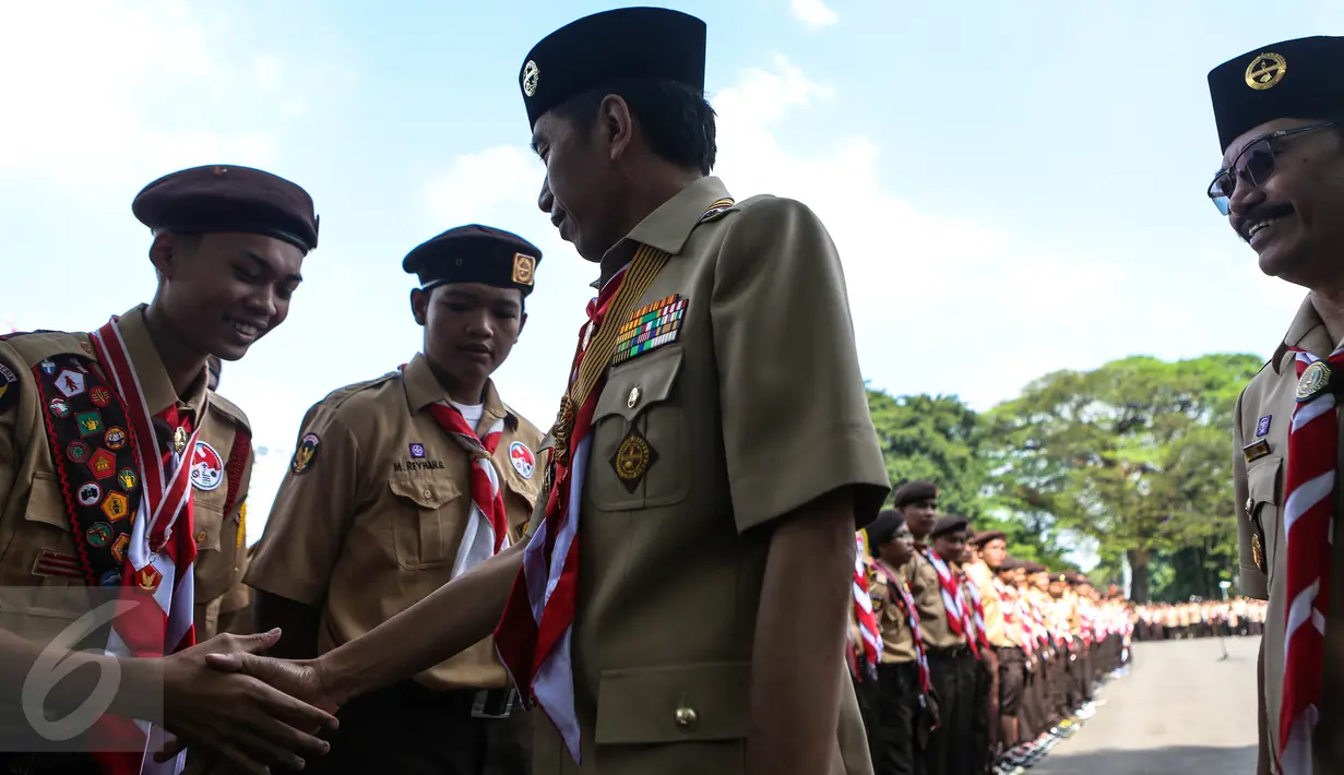 Presiden Jokowi bersalaman dengan delegasi gerakan Pramuka Indonesia di Istana Merdeka, Jakarta, Jumat (24/7). Sebanyak 462 kontingen Pramuka Indonesia akan berkiprah di Jambore Dunia ke-23 di Kirarahama, Yamaguchi, Jepang. (Liputan6.com/Faizal Fanani)