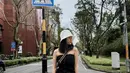 Tube dress jeans hitam makin kece dengan aksesori bucket hat dan sepatu sandal warna putih. [Instagram/azizahsalsha_]