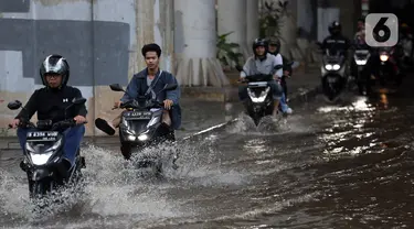 Pengendara melintasi genangan banjir di Jalan Ciledug Raya, kawasan Pasar Cipulir, Jakarta Selatan, Jumat (28/4/2023). (Liputan6.com/Johan Tallo)