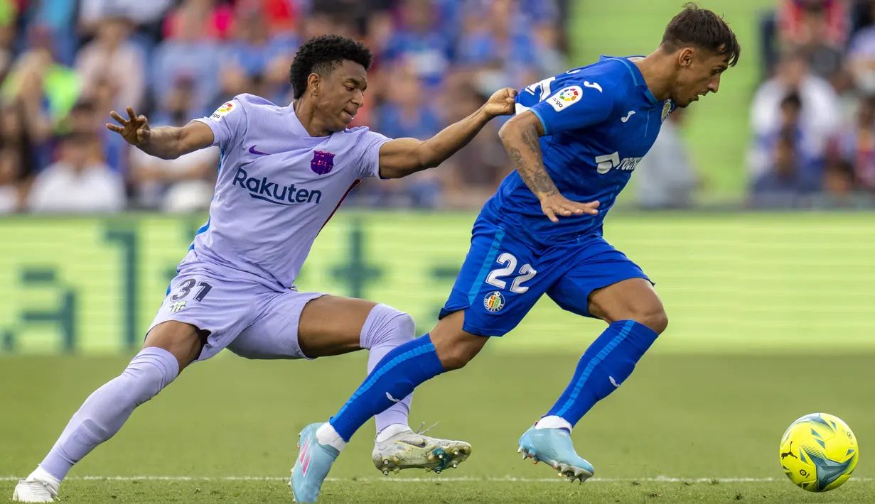 Pemain Getafe Damian Suarez (kanan) berduel memperebutkan bola dengan pemain Barcelona Balde pada pertandingan sepak bola La Liga di Stadion Coliseum Alfonso Perez, Getafe, Spanyol, 15 Mei 2022. Pertandingan berakhir imbang 0-0. (AP Photo/Manu Fernandez)