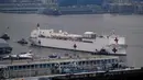 Kapal Rumah Sakit Angkatan Laut USNS Comfort melewati Sungai Hudson saat menuju New York, Amerika Serikat, Senin (30/3/2020). Kapal ini dikerahkan untuk mendukung sistem perawatan kesehatan pasien virus corona COVID-19 di New York. (AP Photo/Craig Ruttle)