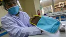Peneliti menunjukkan cara menggunakan masker kain disinfektor berlapis tembaga di Pusat Penelitian Fisika LIPI Puspitek, Serpong, Tangerang Selatan, Senin (8/6/2020). Masker yang diyakini membunuh virus Covid-19 dalam waktu 4 jam telah dilakukan studi case selama 3 bulan. (Liputan6.com/Fery Pradolo)