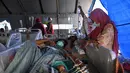Orang-orang yang terluka dalam gempa dengan magnitudo 6,2 menerima perawatan di tempat penampungan sementara di luar Rumah Sakit Regional Sulbar, Mamuju, Sulawesi Barat, Minggu (17/1/2021). Mereka dirawat di dalam tenda darurat untuk mengantisipasi gempa susulan. (ADEK BERRY/AFP)