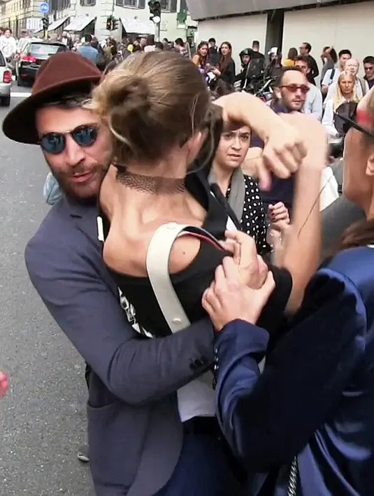 Saat mendekati mobilnya, tiba-tiba seorang lelaki langsung memeluk dan mengangkat tubuh Gigi Hadid dari belakang. Sontak saja kejadian itu membuat kaget dan berusaha untuk melepaskan dari tangan kekar lelaki misterius tersebut. (dok.dailymail.co.uk) 