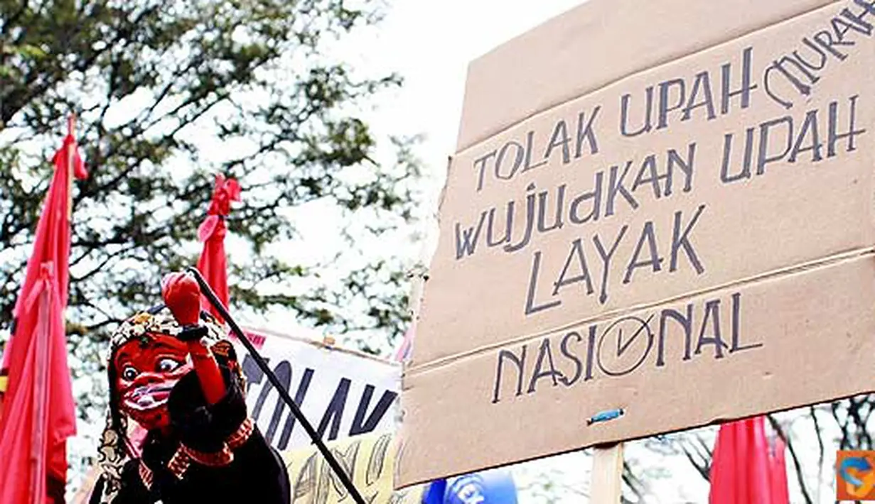 Seorang demonstran memainkan golek pada aksi penolakan sistem kerja kontrak dan outsourcing, dalam rangka Hari Buruh Internasional, di depan Kantor Gubernur Jabar, jalan Diponegoro, Kota Bandung, Minggu (1/5). (Aries Rachmandy)  