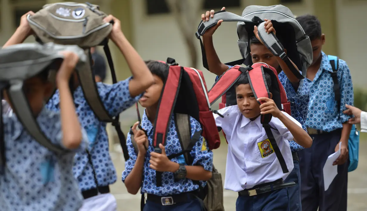 Sejumlah siswa memberikan pertolongan pertama saat simulasi bencana gempa dan tsunami di sebuah sekolah di Banda Aceh, Aceh, Rabu (9/10/2019). Para siswa dibekali wawasan tanggap darurat bencana dan pemberian pertolongan pertama pada korban gempa. (Photo by CHAIDEER MAHYUDDIN / AFP)