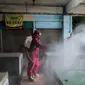 Petugas menyemprotkan Cairan Disinfektan di Pasar Palmerah, Jakarta, Kamis (25/6/2020). Penyemprotan dilakukan guna mencegah dan memutuskan mata rantai penyebaran Covid-19 di Area pasar Palmerah. (Liputan6.com/Johan Tallo)