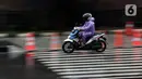 Pengendara mengenakan jas hujan saat melintas di kawasan Kuningan, Jakarta, Kamis (18/12/2021). BMKG memprakirakan potensi hujan lebat yang mungkin disertai petir dan angin kencang hingga 21 Februari di beberapa provinsi di Indonesia, termasuk DKI Jakarta. (Liputan6.com/Helmi Fithriansyah)