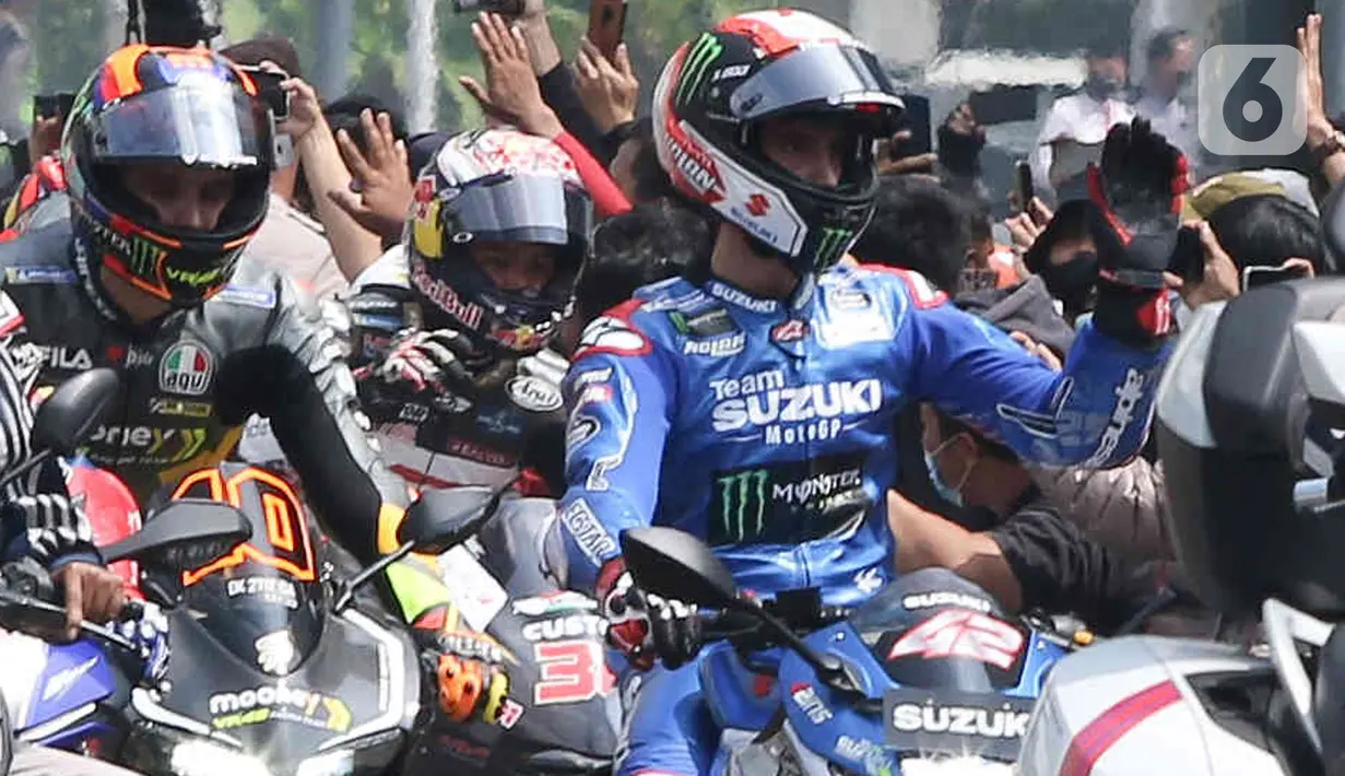 Pembalap MotoGP menyapa penggemar yang menyambut mereka saat melakukan parade di kawasan Bundaran HI, Jakarta, Rabu (16/3/2022). Parade dimulai dari Istana Negara yang dilepas langsung oleh Presiden Republik Indonesia, Joko Widodo. (Liputan6.com/Herman Zakharia)