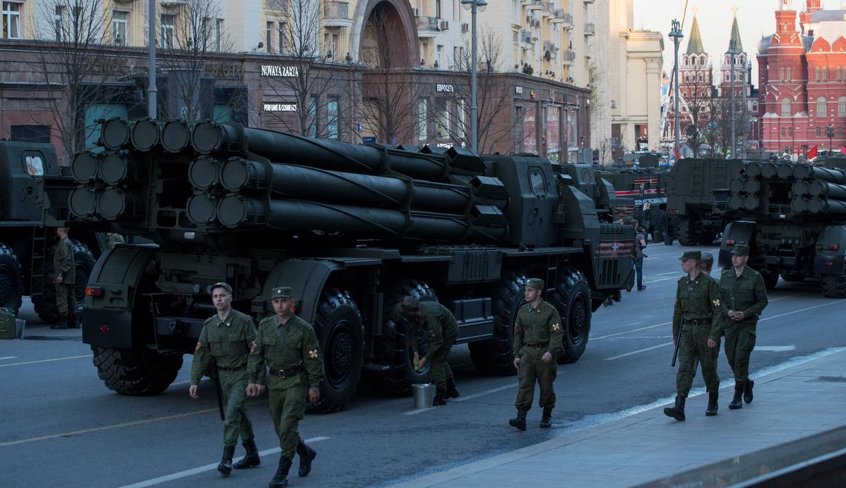 Sejumlah tentara Rusia berjalan di dekata kendaraan militer yang memenuhi jalanan saat melakukan latihan untuk parade militer Hari Kemenangan di Moskow, Rusia (3/5). (AP Photo / Pavel Golovkin)