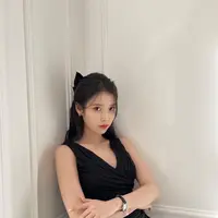 Di dalam foto ini, IU memamerkan gaya rambut half-ponytail. Dengan gaun hitam, rambut hitam panjangnya diambil separuh, lalu ditambahkan pemanis pita besar yang juga berwarna hitam. Beberapa helai rambut dibiarkan tergerai di depan sebagai pemanis tampilan. Foto: Instagram.