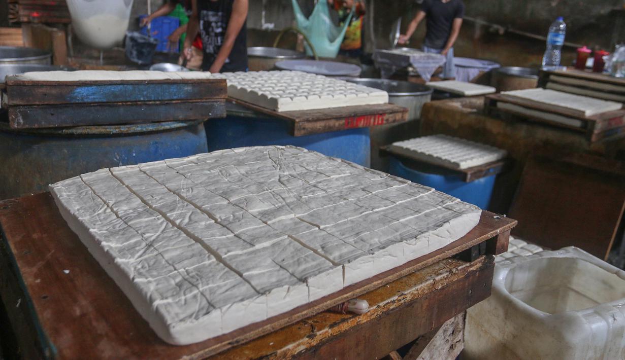 Sementara itu, di tingkat pedagang pasar tradisional harga kedelai mencapai Rp15.000 hingga Rp20.000 per kilogram, meningkat dari sebelumnya Rp 13.000 hingga Rp 18.000 per kilogram. Tampak dalam foto, perajin menyelesaikan pembuatan tahu di Duren Tiga Jakarta Selatan, Selasa 14 April 2026, di tengah kenaikan harga kedelai yang berdampak pada biaya produksi. (merdeka.com/Arie Basuki)