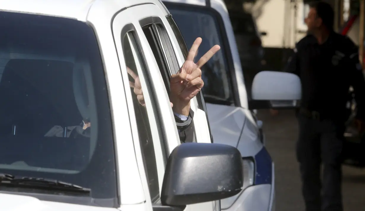 Pembajak pesawat EgyptAir, Seif Eldin Mustafa mengacungkan dua jarinya kepada awak media di dalam mobil tahanan di sebuah pengadilan di Larnaca, Siprus (30/3). Seif Eldin Mustafa menyerahkan diri dan membebaskan 5 sandera. (REUTERS/Yiannis Kourtoglou)