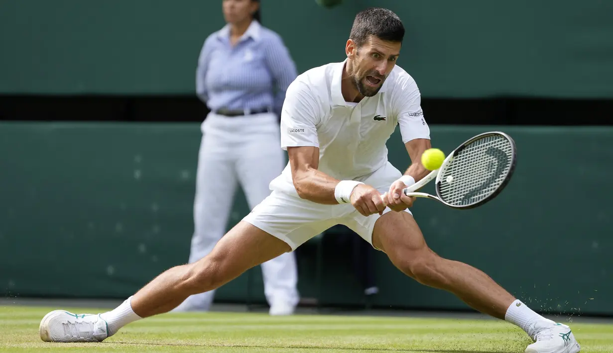 Petenis Serbia, Novak Djokovic berusaha mengembalikan bola saat menghadapi petenis Spanyol, Carlos Alcaraz pada laga final tunggal putra turnamen tenis Grand Slam Wimbledon 2023 di All England Lawn and Tennis Club, London, Minggu (16/7/2023) malam WIB. (AP Photo/Kirsty Wigglesworth)