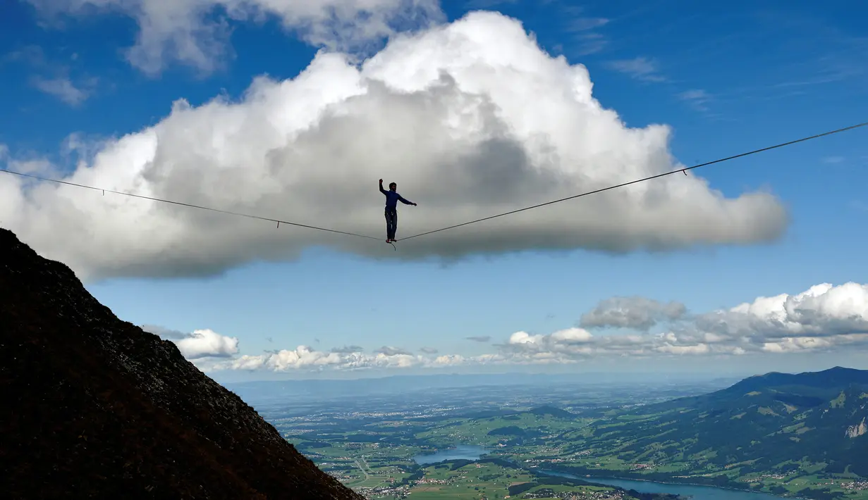 Daniel Laruelle dari Afrika Selatan berjalan diatas tali saat acara Highline Extreme di puncak Moleson, Swiss (15/9). Perlombaan berjalan di seutas tali diatas ketinggian ini diikuti oleh lima puluh slackliner terbaik Dunia. (AFP Photo/Michael Buholzer)