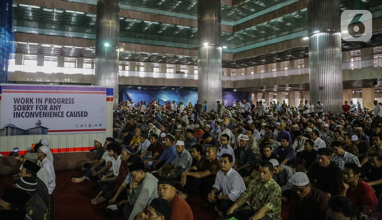Jemaah mendengarkan ceramah saat melaksanakan salat Jumat di samping renovasi Mesjid Istiqlal, Jakarta, Jumat (1/11/2019). Renovasi ditargetkan rampung pada Maret 2020 sehingga dapat dimanfaatkan pada Bulan Ramadan tahun depan. (Liputan6.com/Faizal Fanani)