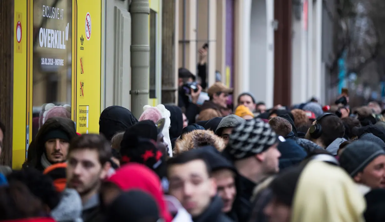 Antrean calon pembeli sepatu Adidas/BVG (Berlin Transport) di luar toko Overkill di Berlin, Jerman, Selasa (16/1). Toko itu hanya menyediakan 500 pasang sepatu olahraga terbaru dari Adidas yang disebut-sebut paling canggih. (AFP PHOTO / Odd ANDERSEN)