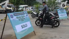 Warga calon pemudik mendorong motor yang hendak diangkut menuju kampung halaman di Terminal Pulogadung, Jakarta, Selasa (2/4/2024). (merdeka.com/Imam Buhori)