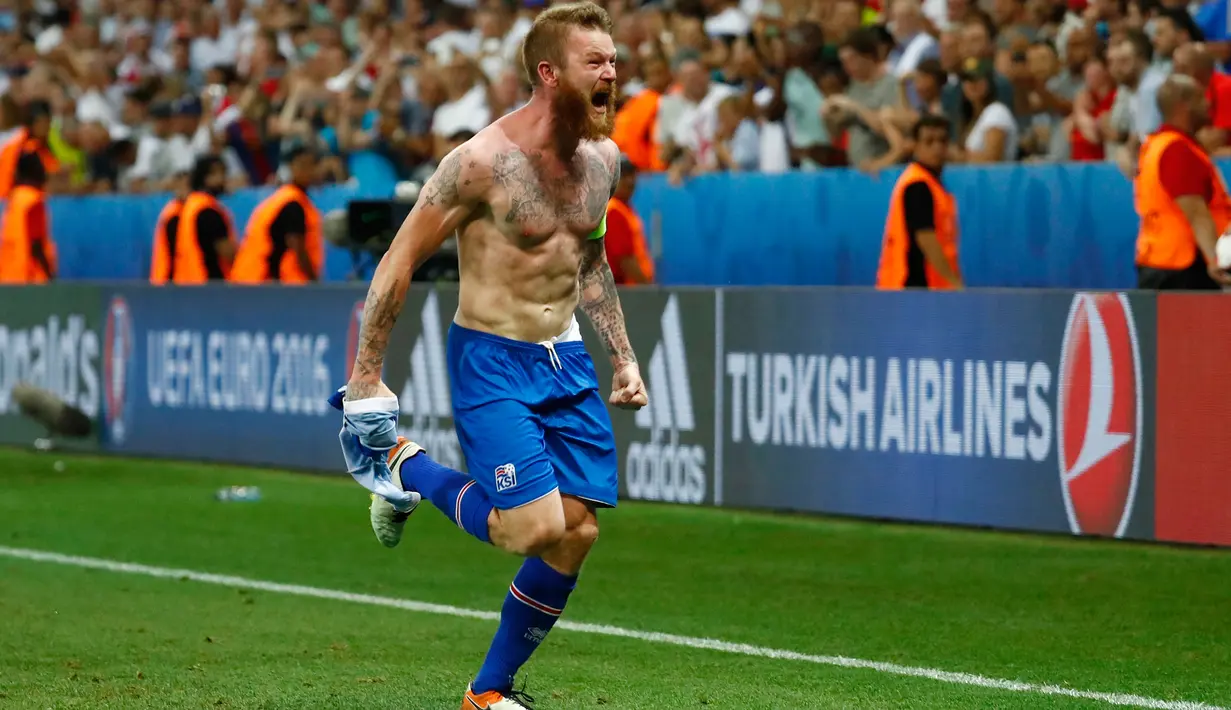 Aksi selebrasi Kapten timnas Islandia, Aron Gunnarsson melepas jerseynya untuk merayakan kemenangan Islandia atas Inggris, Selasa (28/6) dini hari. Islandia membuat kejutan besar dengan menyingkirkan Inggris dari Piala Eropa 2016. (REUTERS/Michael Dalder)
