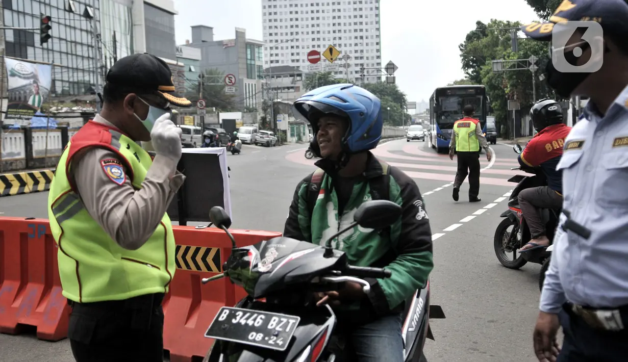 Petugas memberhentikan pengendara motor tanpa mengenakan masker di kawasan Menteng, Jakarta, Senin (13/4/2020). Batas maksimal 50 persen dari kapasitas kendaraan roda empat, berkendara dalam keadaan sakit, dan batas operasional kendaraan umum hingga pukul 18.00 WIB. (merdeka.com/Iqbal S. Nugroho)