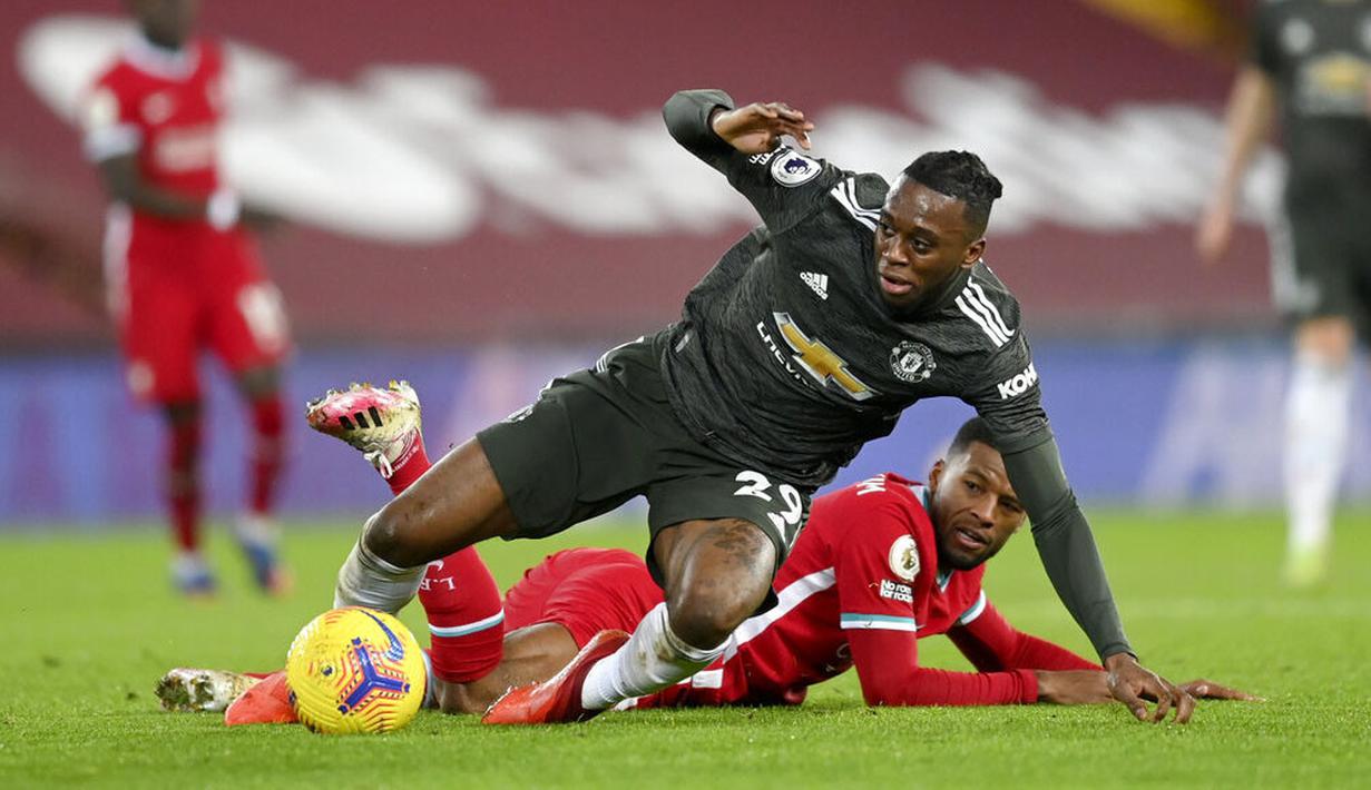 Pemain Manchester United, Aaron Wan-Bissaka, berebut bola dengan pemain Liverpool, Georginio Wijnaldum, pada laga Liga Inggris di Stadion Anfield, Minggu (17/1/2021). Kedua tim bermain imbang 0-0. (Michael Regan/Pool via AP)