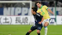 Pemain Jepang, Takefusa Kubo (kiri), berduel dengan pemain Brasil, Carlos Augusto, dalam laga persahabatan di Tokyo, Selasa, 14 Oktober 2025. (AP Photo/Eugene Hoshiko)