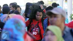 Seorang pemudik memanggul barang bawaannya di Stasiun Senen Jakarta, Sabtu (2/7). Ribuan pemudik kembali memadati Stasiun Senen untuk berangkat menuju kota kota di pulau Jawa. (Liputan6.com/Helmi Fithriansyah)
