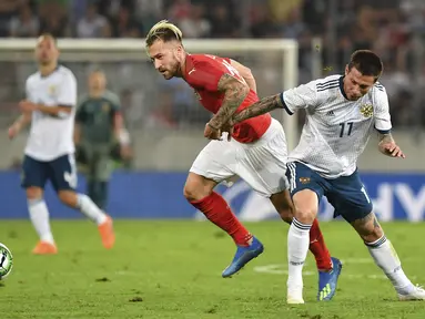 Pemain Austria, Peter Zulj (kiri) berebut bola dengan pemain Rusia, Fedor Smolov pada laga uji coba di Tivoli Stadium, Innsbruck, Austria, (30/5/2018). Austria menang atas Rusia 1-0. (AP/Kerstin Joensson)