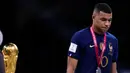 Pemain Prancis Kylian Mbappe tertunduk saat berjalan melewati trofi Piala Dunia 2022 usai melawan Argentina pada pertandingan final di Stadion Lusail, Lusail, Qatar, 18 Desember 2022. Argentina menang 4-2 dalam adu penalti melawan Prancis setelah pertandingan berakhir imbang 3 -3. (AP Photo/Manu Fernandez)
