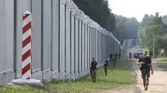 Penjaga perbatasan Polandia berpatroli di area tembok baja yang baru dibangun di perbatasan antara Polandia dan Belarusia, dekat Kuznice, Kamis (30/6/2022). Perdana Menteri Polandia Mateusz Morawiecki mengunjungi daerah perbatasan untuk menandai selesainya pembangunan tembok baja baru. (AP Photo/Michal Dyjuk)