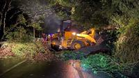 Petugas BPBD Kota Batu membersihkan pohon dan material lumpur akibat tebing longsor di Jalan Trunojoyo (Payung) pada Kamis, 2 Maret 2023 malam. Petugas menerapkan sistem buka tutup di&nbsp;jalur penghubung Malang - Kediri ini (Foto : BPBD Kota Batu)&nbsp;&nbsp; &nbsp;&nbsp;