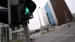 Lampu lalu lintas khusus pejalan kaki yang menampilkan simbol wanita di Vilnius, Lituania, Jumat (2/11). Hal itu untuk merayakan ulang tahun ke-100 wanita memperoleh pengakuan internasional dalam pemungutan suara di negara baltik. (Petras Malukas/AFP)