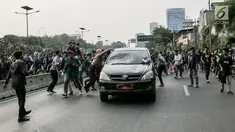Massa aksi  melakukan penyerangan terhadap mobil pelat nomor merah yang melintasi jalan tol seberang Gedung DPR/ MPR RI, Jakarta, Selasa (24/9/2019). Selain menutup ruas tol, kendaraan dinas pemerintah dan milik polisi jadi korban pelemparan dan perusakan oleh mahasiswa. (Liputan6.com/Faizal Fanani)