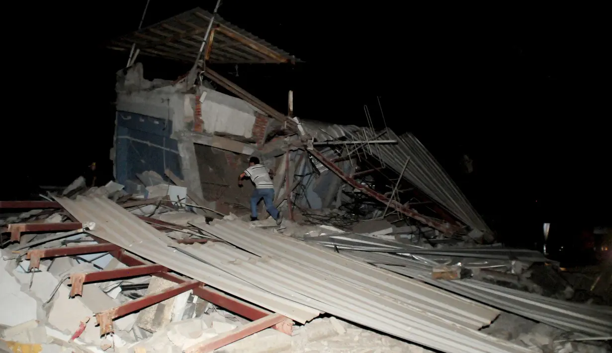 Seorang warga mencari korban di reruntuhan bangunan pasca diguncang Gempa berkekuatan 7,8 SR, Kota Manta, Ekuador, Sabtu (16/4).Kabarnya gempa yang terjadi di lepas pantai Pasifik itu berpotensi menimbulkan tsunami. (REUTERS/Paul Ochoa)