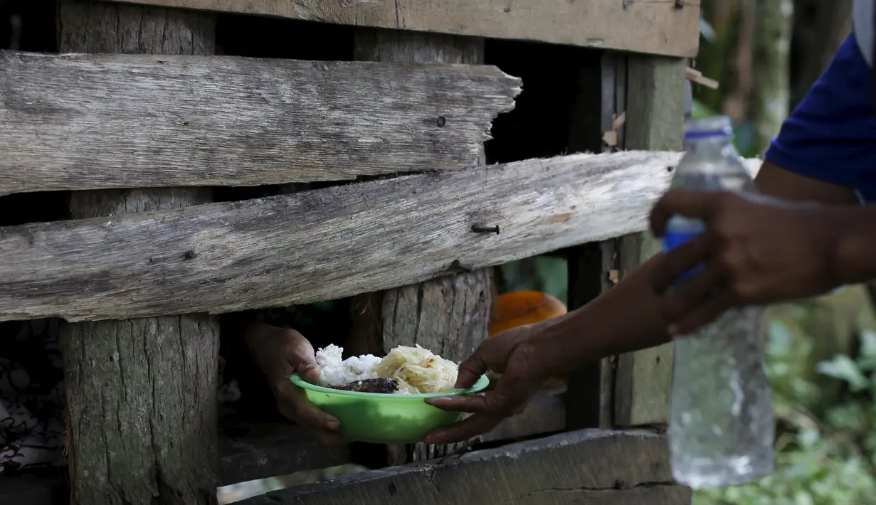 Jumia saat diberi makan oleh keluarganya saat dipasung di desa Jambu, Serang, Banten, Indonesia (23/3). Tahun ini Indonesia mengirimkan tim medis untuk membantu pasien yang mengalami ganguan mental. (REUTERS/Beawiharta)