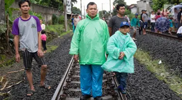 Warga melihat proses evakuasi KRL yang anjlok di kawasan Kebon Pedes, Bogor, Jawa Barat, Minggu (10/3). Kepala Daop I Jakarta Dadan Risdiansyah memastikan penanganan KRL yang anjlok selesai hari ini. (Liputan6.com/Immanuel Antonius)