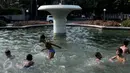 Anak-anak  berenang di kolam air mancur di kawasan Jalan Diponogoro, Jakarta, Jumat (31/7/2015). Minimnya lahan bermain di Ibukota, membuat mereka memanfaatkan kolam air mancur sebagai tempat berenang. (Liputan6/Johan Tallo)