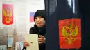 Seorang perempuan meninggalkan bilik suara di sebuah tempat pemungutan suara dalam pemilihan presiden di Sankt Peterburg, Rusia, Sabtu, 16 Maret 2024. (AP Photo/Dmitri Lovetsky)