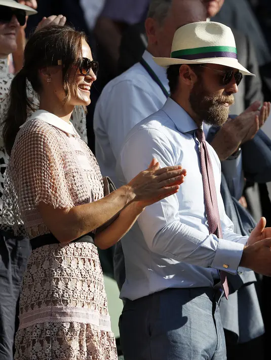 Pippa Middleton bersama adiknya, James Middleton, menyaksikan hari ketiga kejuaraan tenis Grand Slam Wimbledon 2017 di London, Rabu (5/7). Gaun Berbahan brokat yang menerawang tersebut mengekspos tubuh Pippa yang ramping. (Adrian DENNIS / AFP)