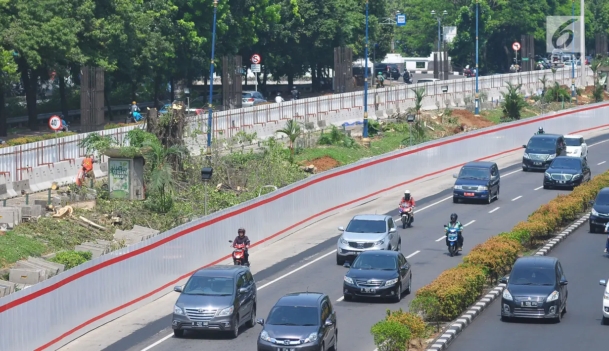 Kendaraan melintas di samping proyek kereta api ringan atau LRT di kawasan Kuningan, Jakarta, Rabu (26/7). Bersamaan dengan dua koridor lain dalam tahap pertama proyek LRT Jakarta Bogor Depok Bekasi (JABODEBEK). (Liputan6.com/Helmi Afandi)