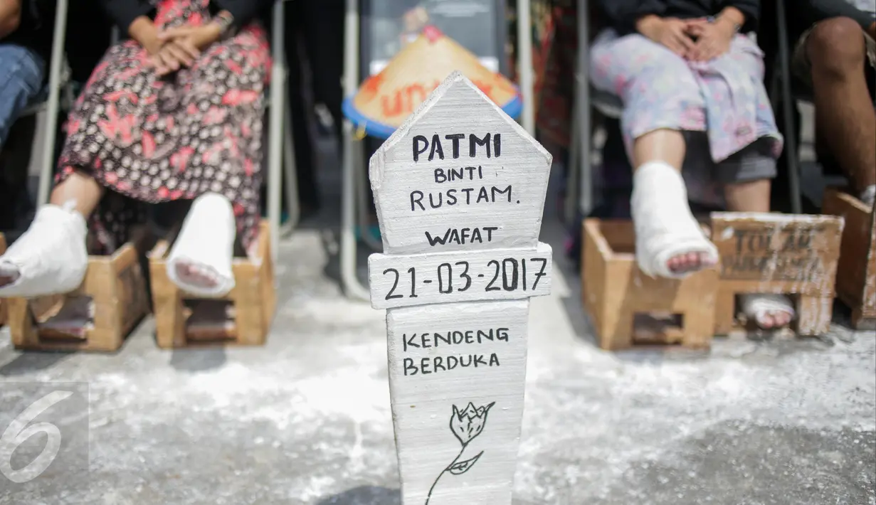 Sebuah nisan untuk Patmi (48), peserta aksi semen kaki yang meninggal, di depan Istana Merdeka, Jakarta, Rabu (22/3). Delapan aktivis menggelar aksi semen kaki yang sekaligus menghormati dan melanjutkan perjuangan Ibu Patmi. (Liputan6.com/Faizal Fanani)