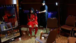 Penata rias menata rambut wanita korban serangan cairan asam sebelum tampil pada pagelaran busana "Beauty Redefined" di Dhaka, Bangladesh, 7 Maret 2017. Peragaan ini untuk menumbuhkan pemahaman warga terhadap kejahatan cairan asam. (AP Photo/A. M. Ahad)