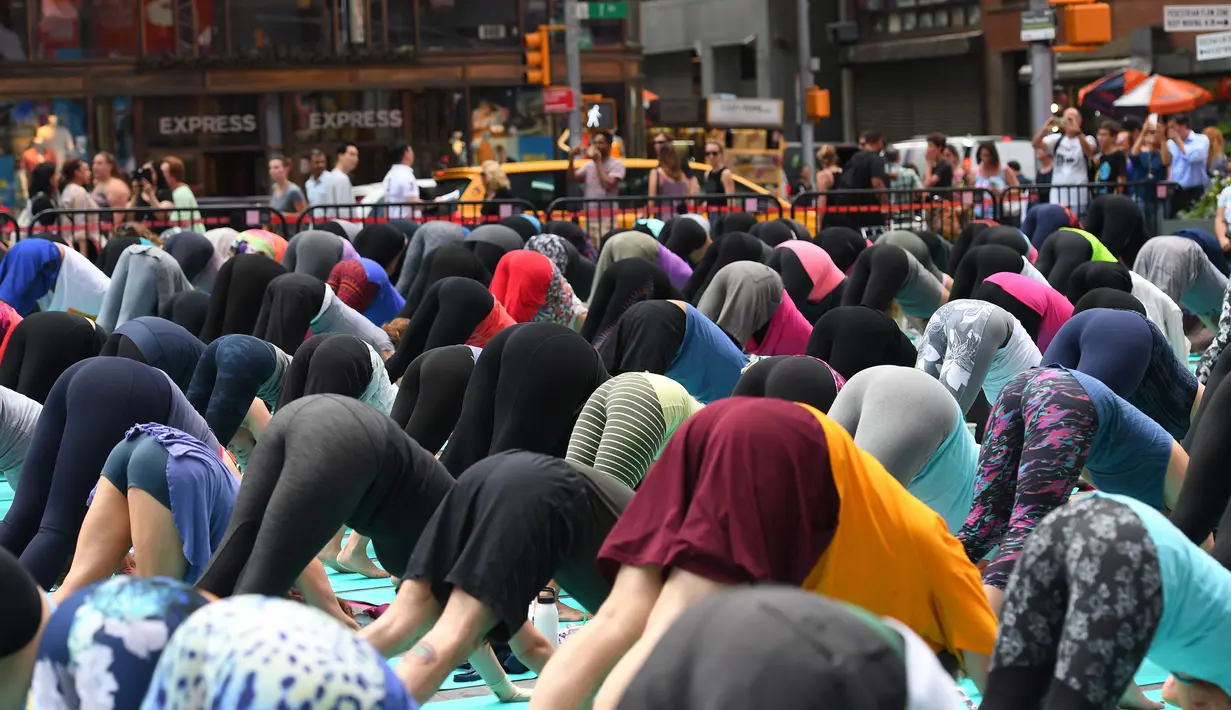 Sejumlah orang melakukan gerakan yoga di tengah jalan Times Square, New York pada 'Summer Solstice' atau hari dengan siang terpanjang di musim panas, Rabu (21/6). Acara itu menandai Hari Yoga Internasional yang jatuh pada 21 Juni. (TIMOTHY A. CLARY/AFP)