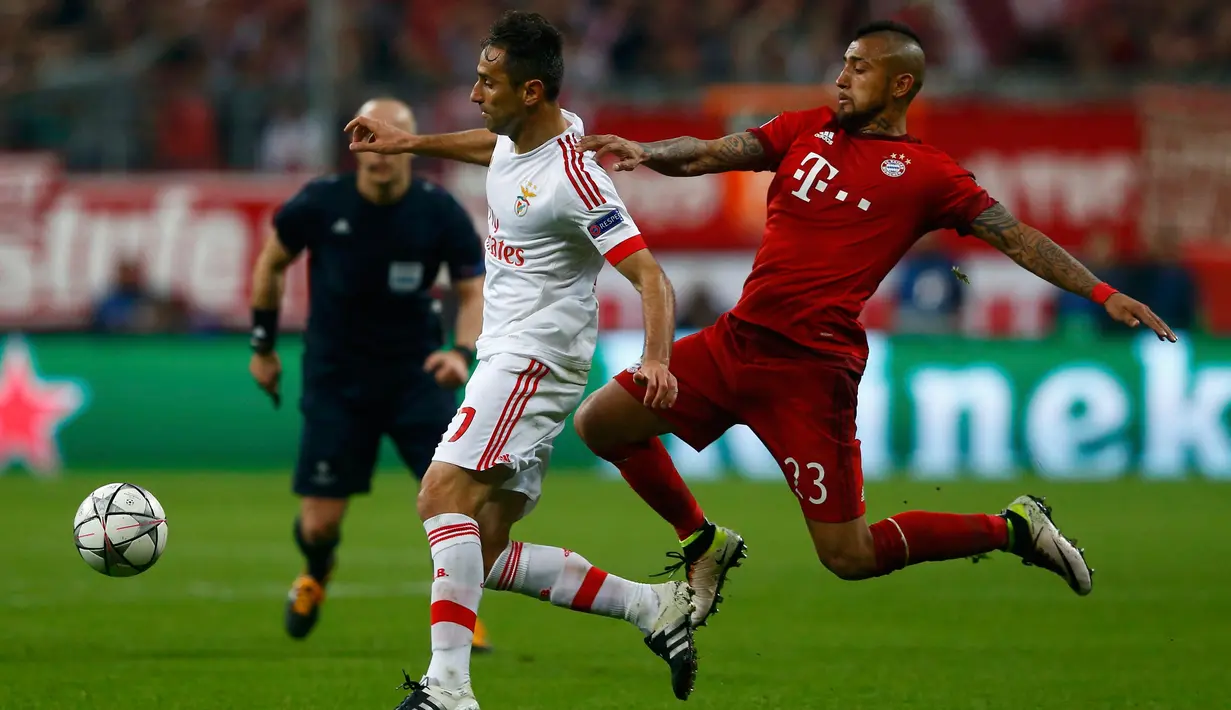 Penyerang Benfica, Jonas (kiri) berusaha membawa bola dari kejaran gelandang Muenchen, Arturo Vidal pada leg pertama liga champions di Allianz Arena, Munich, Jerman, (6/4). Muenchen menang tipis atas Benfica dengan skor 1-0. (REUTERS/Michael Dalder)