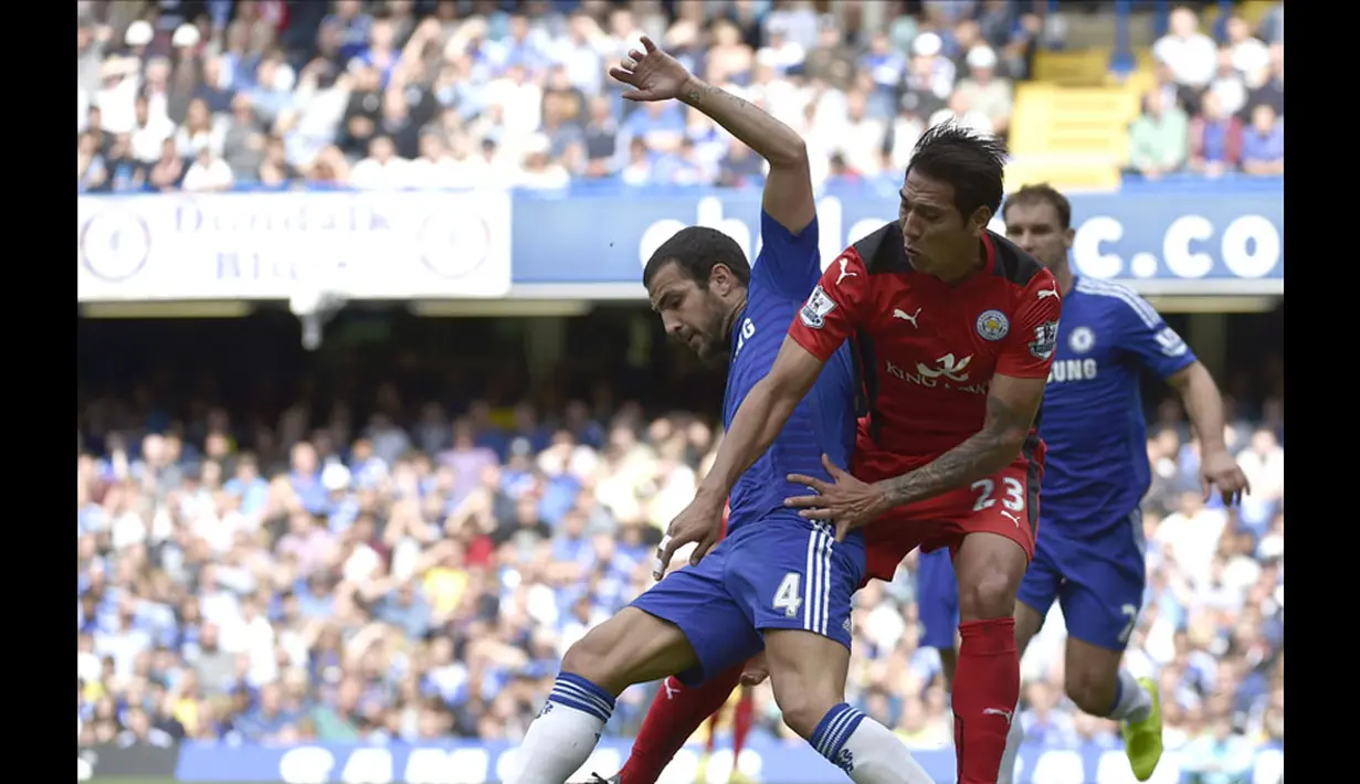 Gelandang Chelsea, Cesc Fabregas (kiri), berdule berebut bola dengan pemain depan Leicester City, Leonardo Ulloa, di laga lanjutan Liga Primer Inggris di Stadion Stamford Bridge, London, (23/8/2014). (REUTERS/Toby Melville)